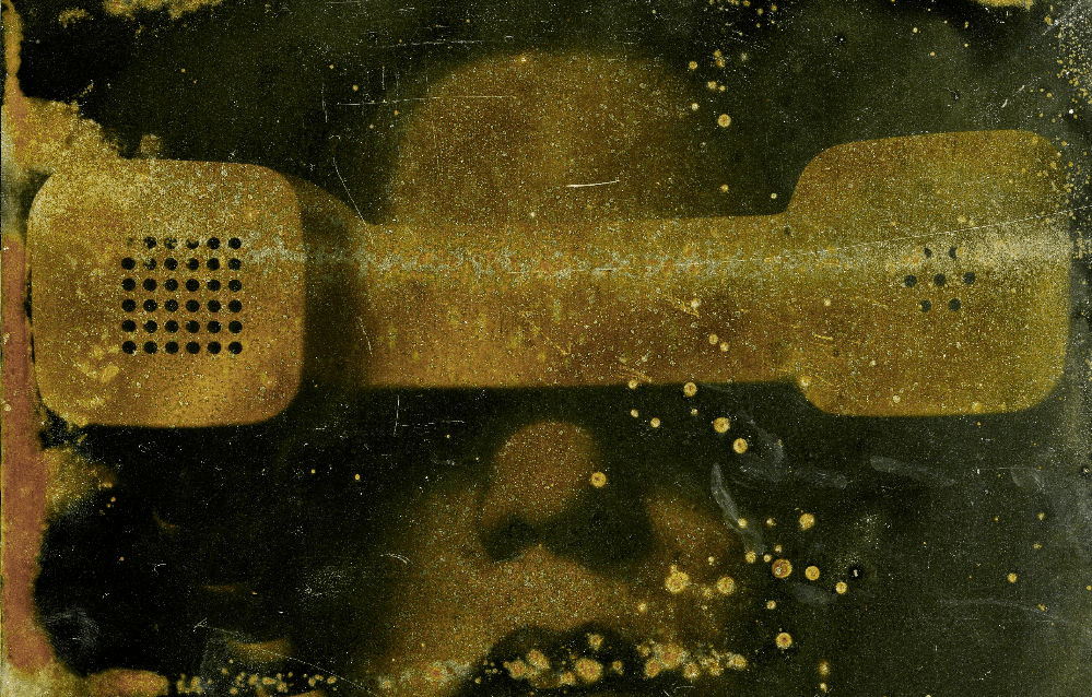 An image of a woman holding a phone over her eyes.